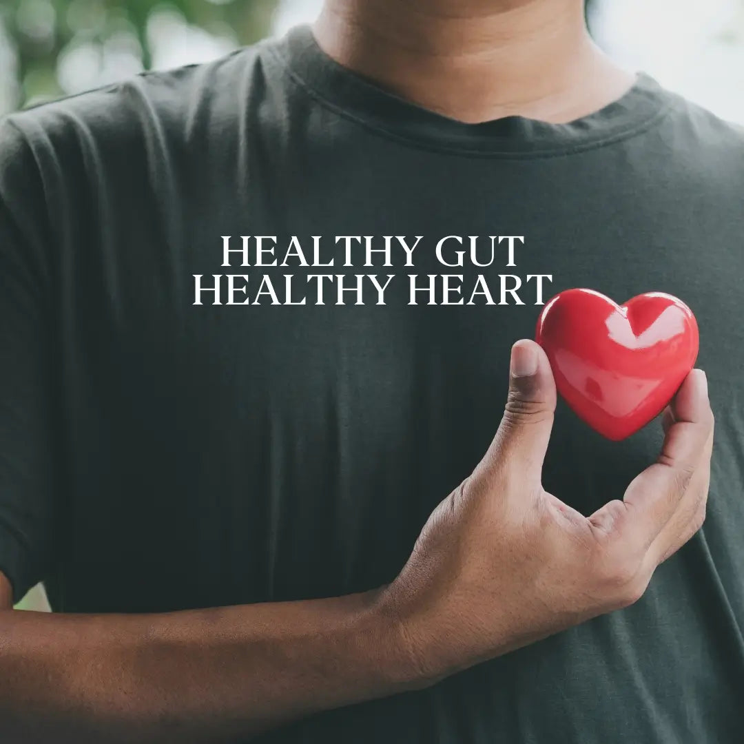 Person holding red heart over chest representing heart health.