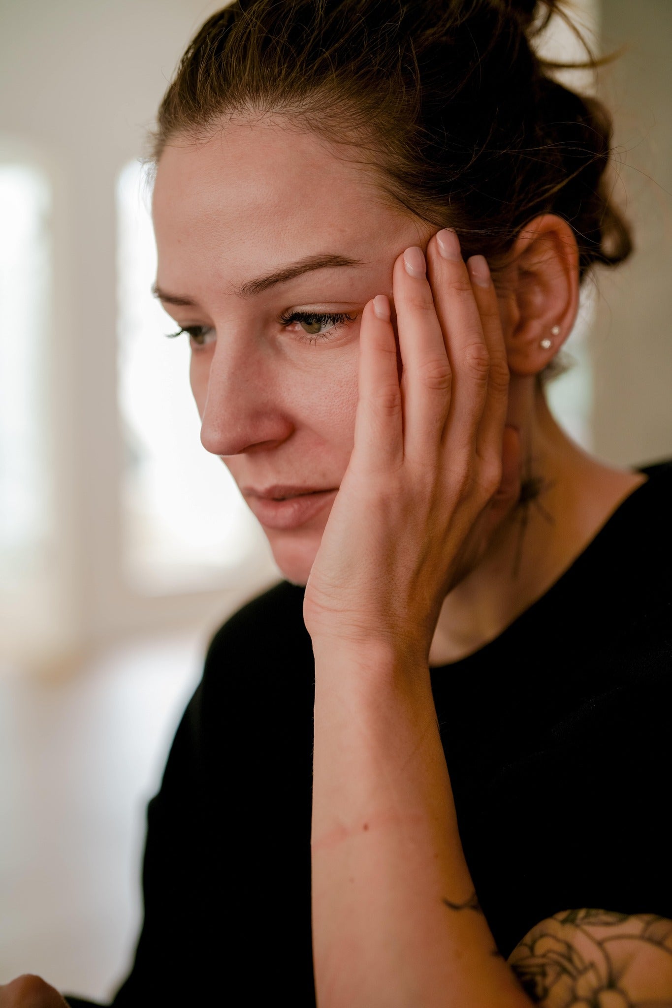 woman with hands next to her temple experiencing anxiety and stress.