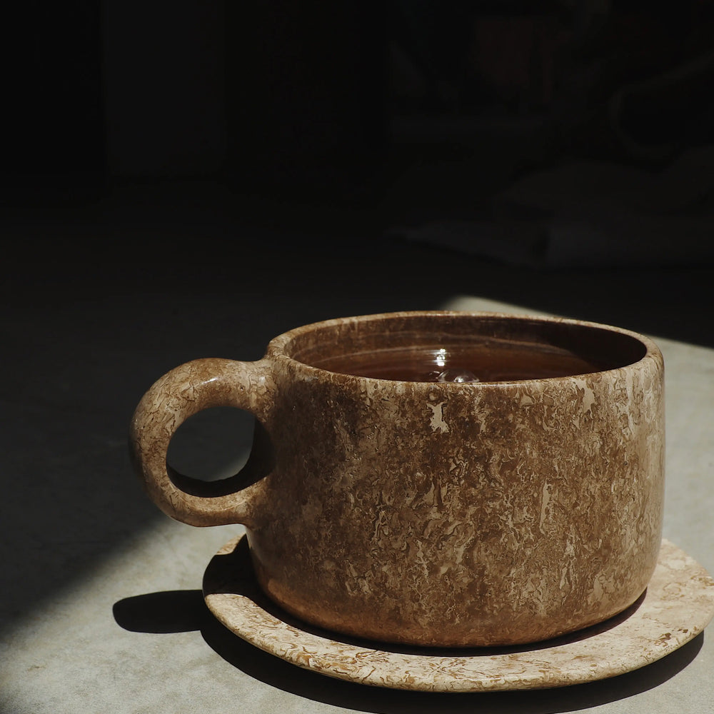 Brewed cup of Woodroot Spiced Tea in a stone cup.