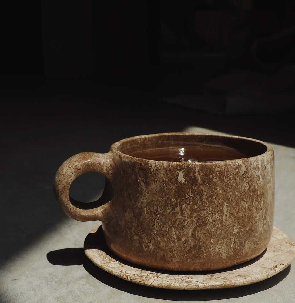 Stone cup of hot Woodroot Spiced Tea.