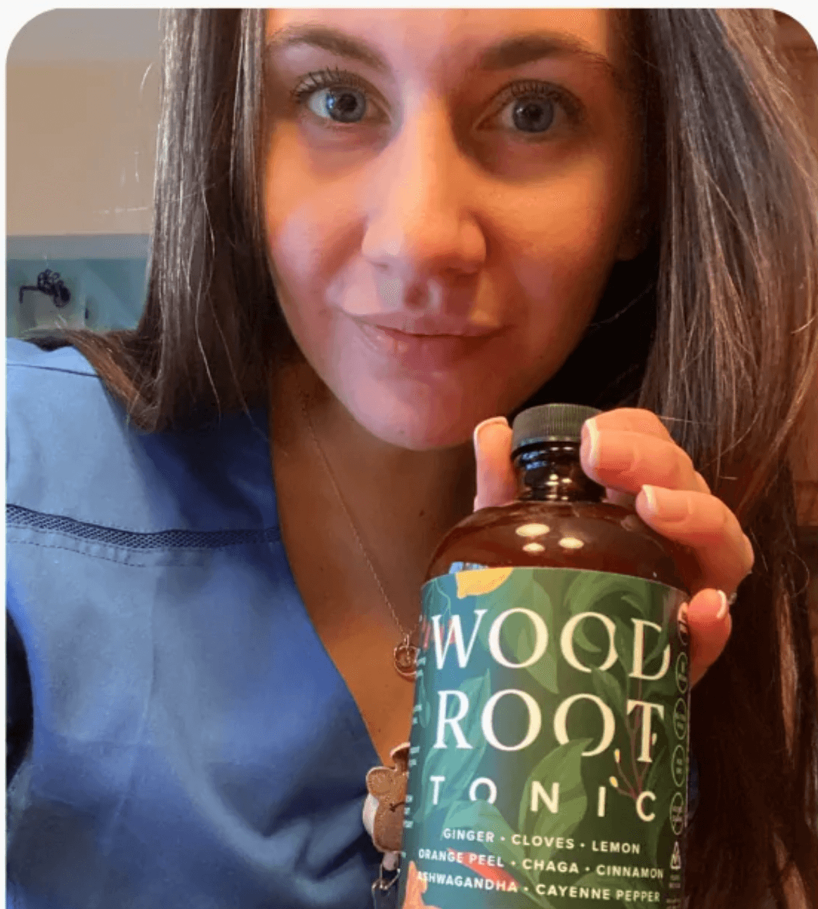 Nurse holding a bottle of Woodroot Tonic, a dietary supplement for gut and immune health.