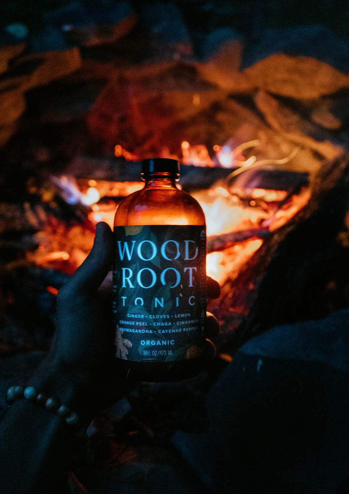 Bottle of Woodroot Tonic next to fire.