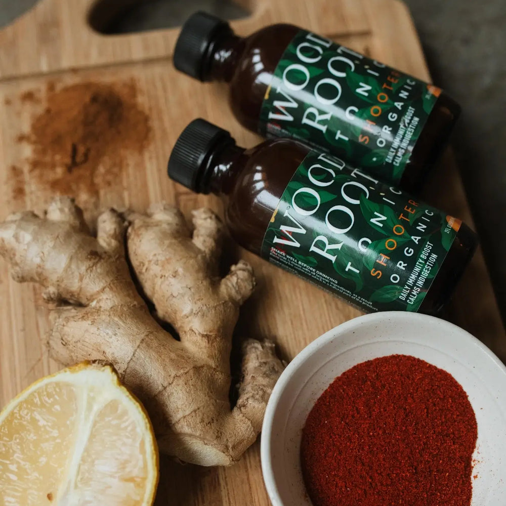 
                  
                    Woodroot Tonic shooters next to key ingredients; ginger, lemon, and cayenne. 
                  
                