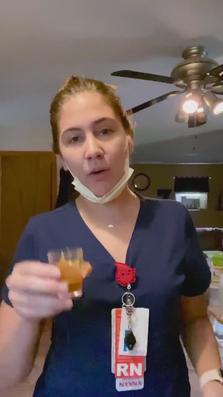 Video of woman taking a shot of Woodroot Tonic to start her day. 