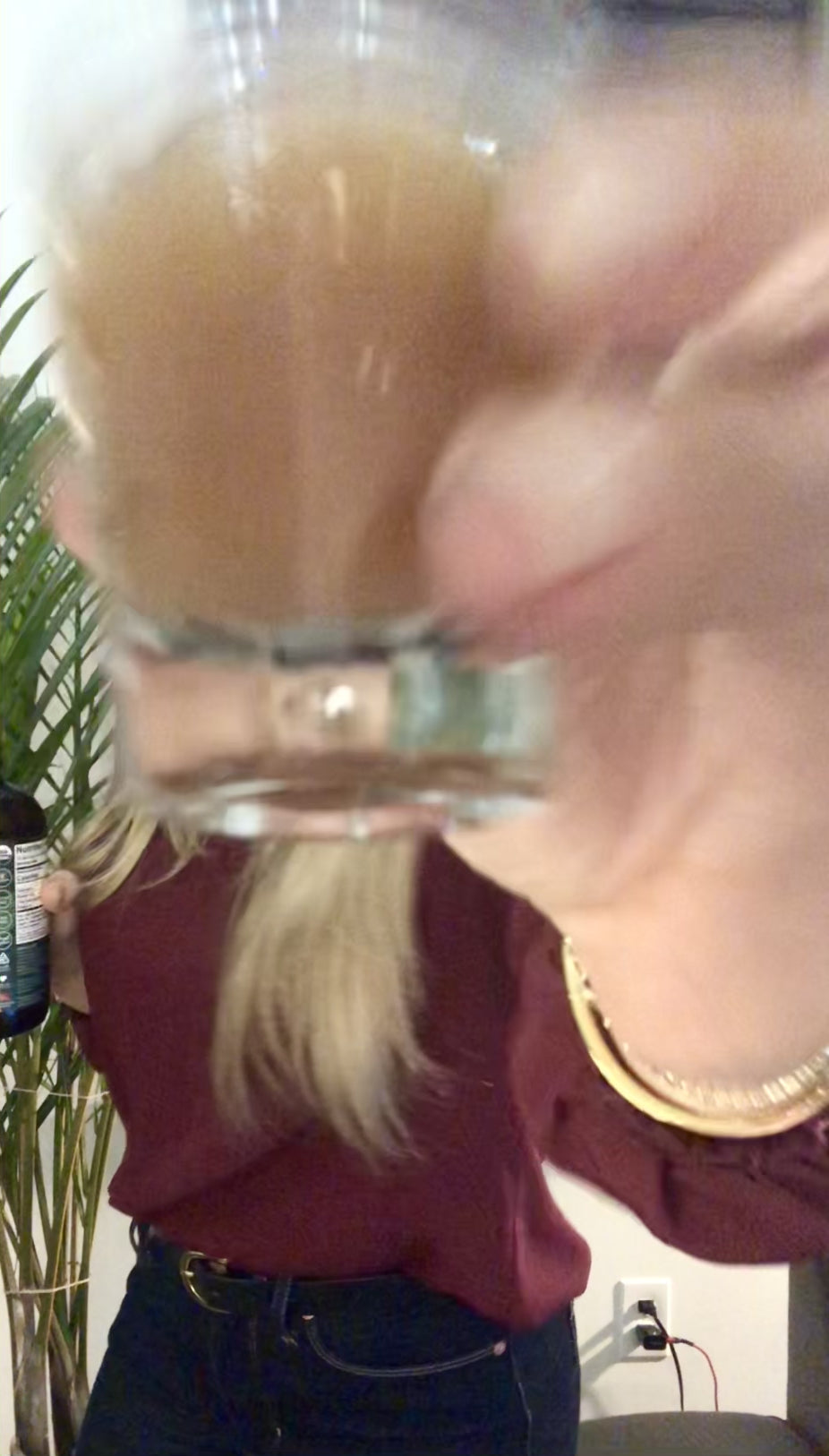 Woman taking a Woodroot Tonic shot to decrease inflammation in the gut and support overall gut health. 
